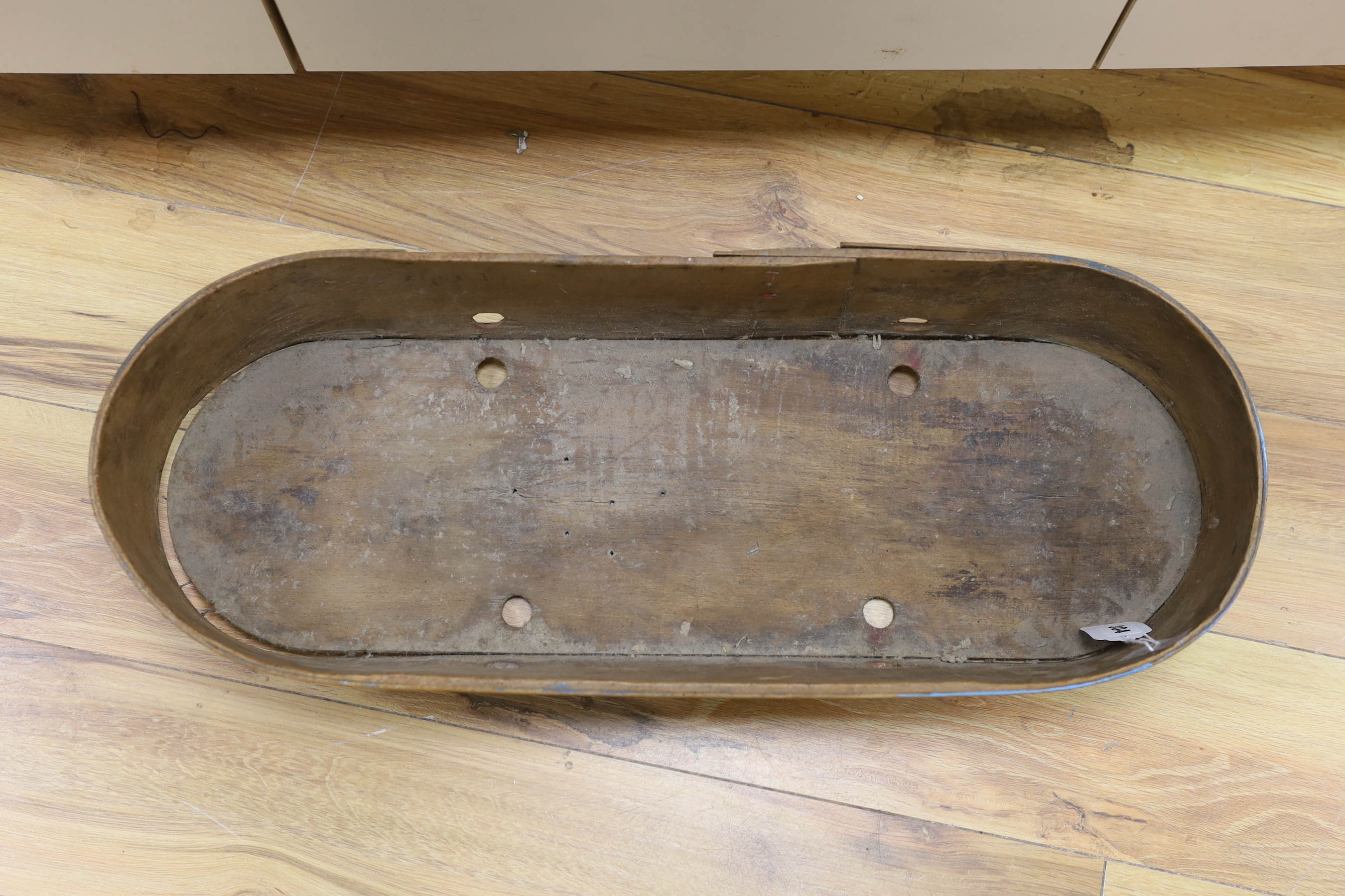 A 19th century Greek painted bentwood trough, decorated with multicoloured flowers on a mid blue background, 69cm wide, 15cm high
